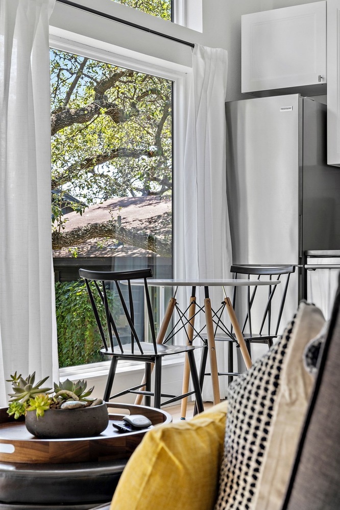 ADU dining nook by RedOven Builds in 3102 S Oak Dr TX with round table and large window overlooking trees