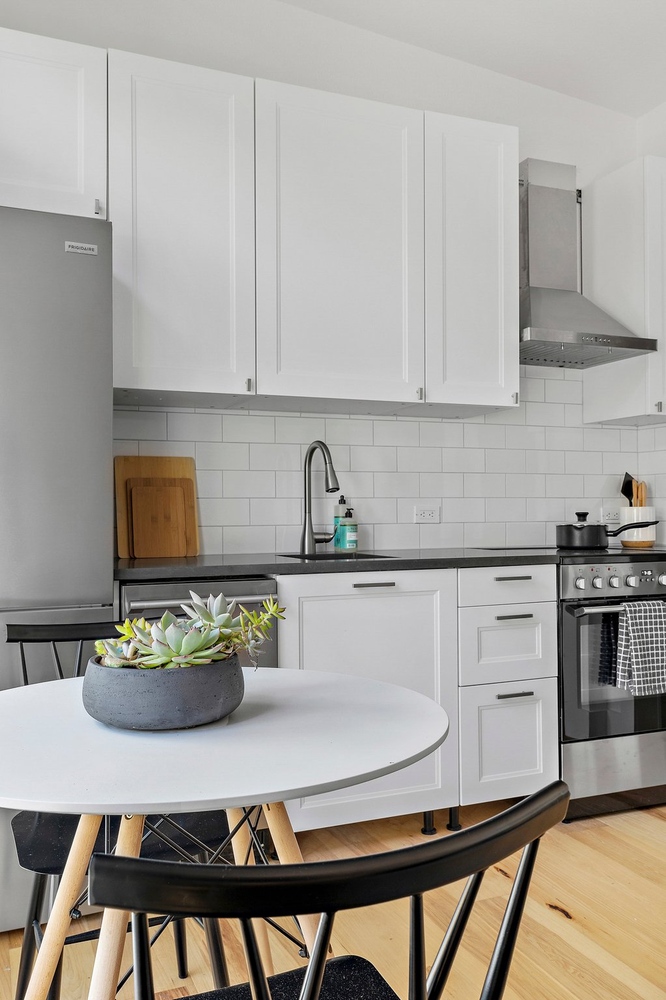 ADU kitchen close-up by RedOven Builds in 3102 S Oak Dr TX with white cabinets, stainless appliances, and round dining table