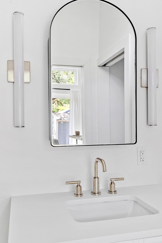 contemporary ADU vanity detail by RedOven Builds in 3102 S Oak Dr TX featuring arched mirror and clean lines