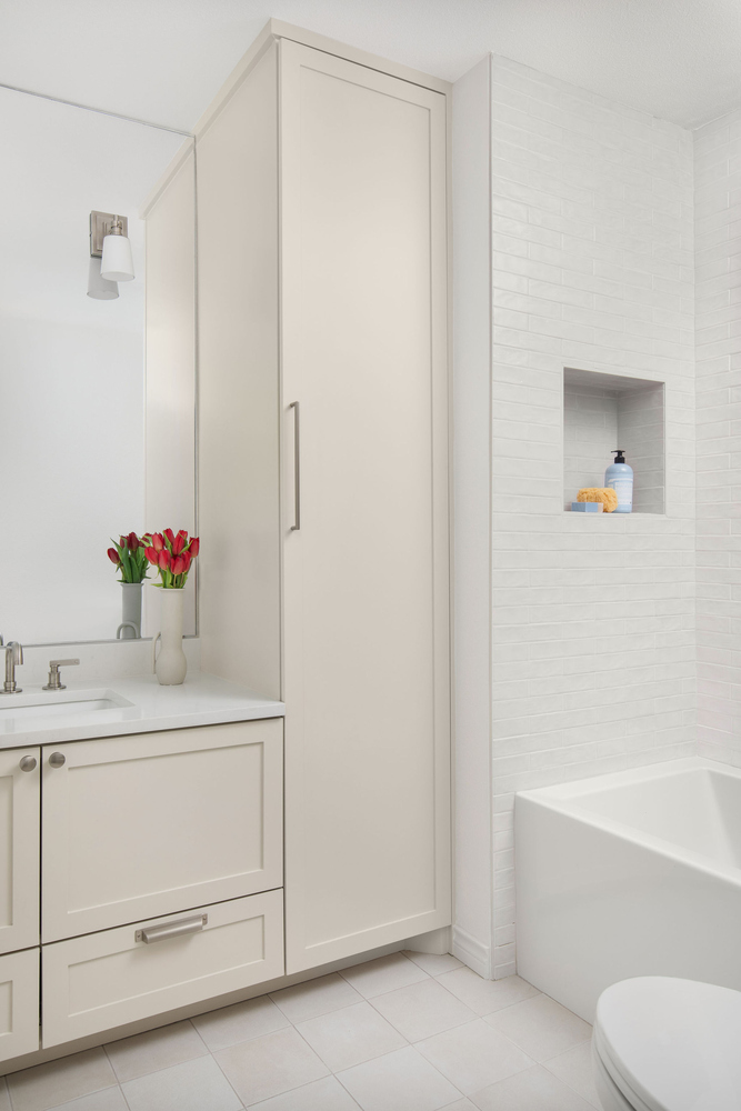 clean bathroom design in Whitemarsh Austin TX by RedOven Builds featuring built-in tub and tall cabinet