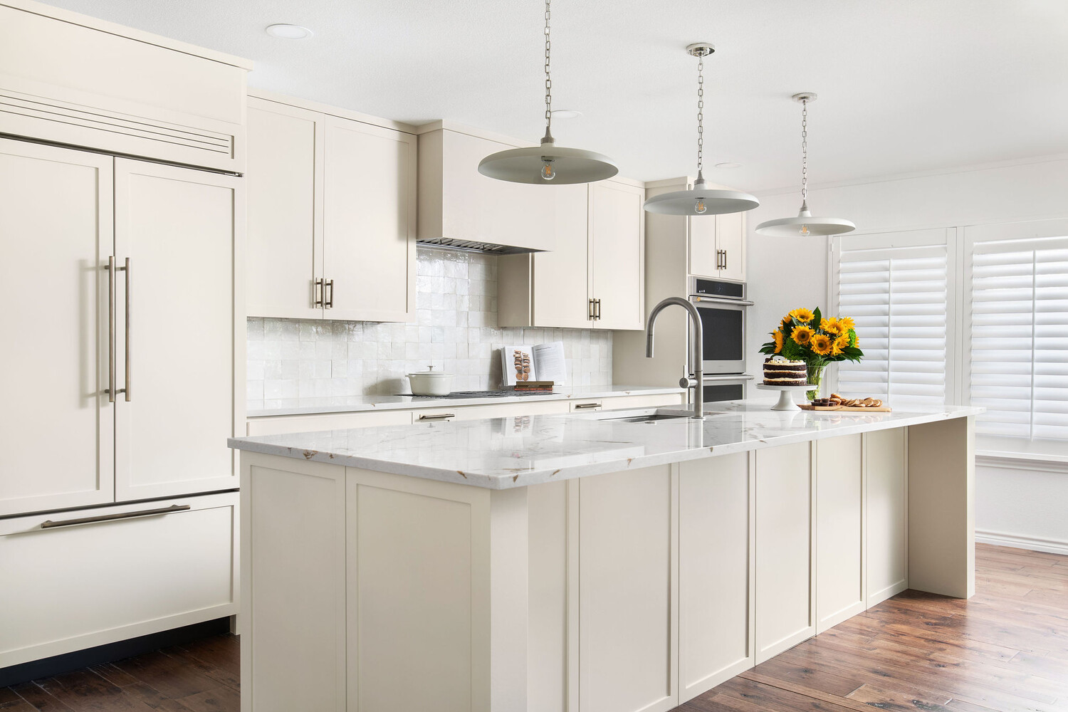 modern kitchen remodel by RedOven Builds in Whitemarsh Austin TX featuring white shaker cabinets and large marble island