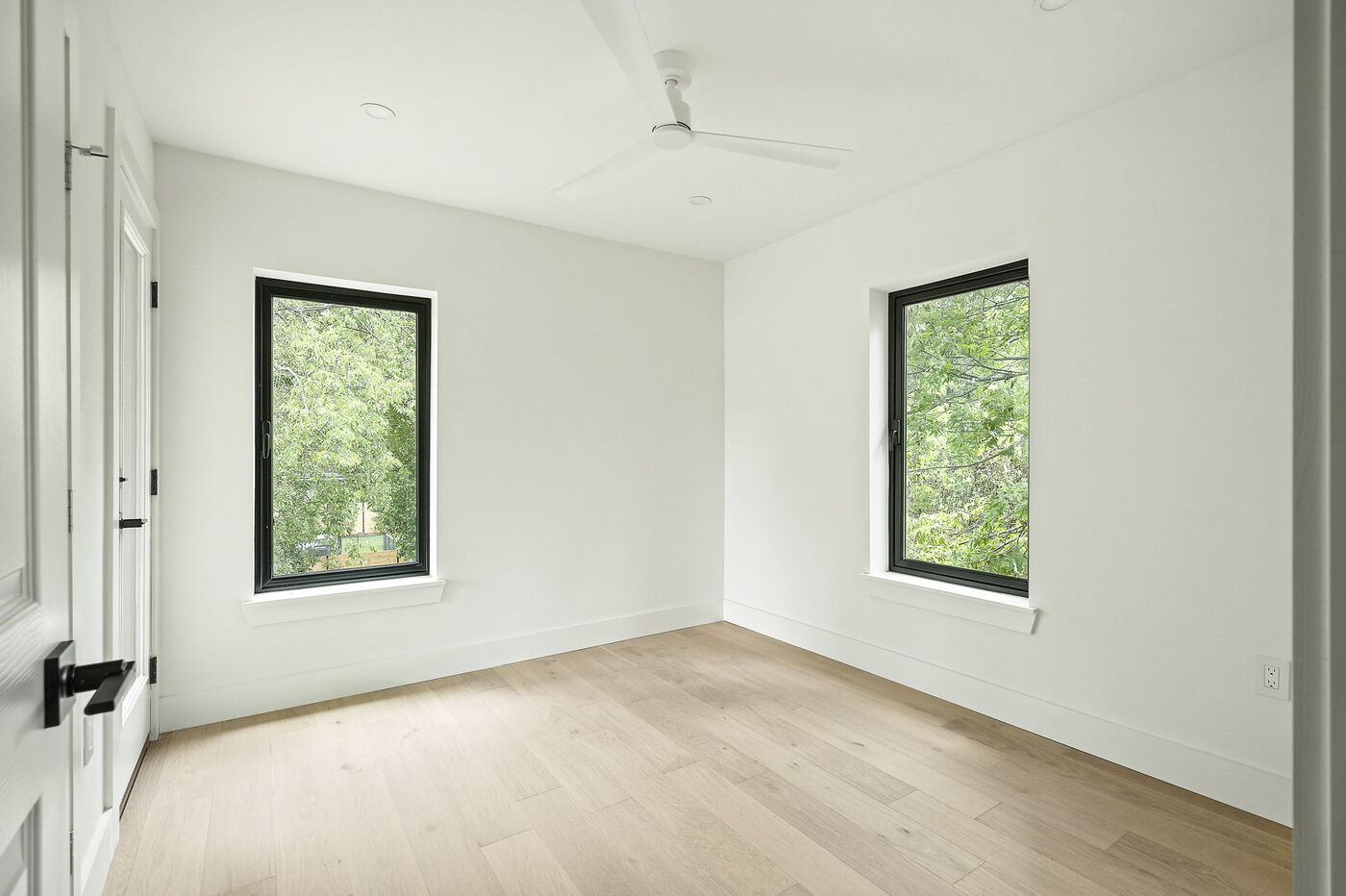Bright bedroom with two large windows and ceiling fan in Brentwood, TX ADU by RedOven Builds
