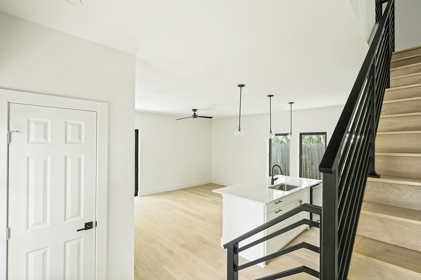 Open living area with kitchen island and staircase in Brentwood, TX ADU by RedOven Builds