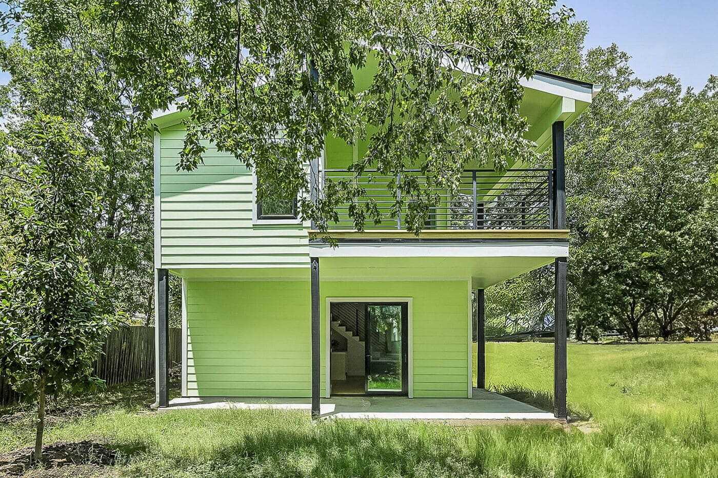 Two-story green ADU with balcony and covered patio in Brentwood, TX, built by RedOven Builds