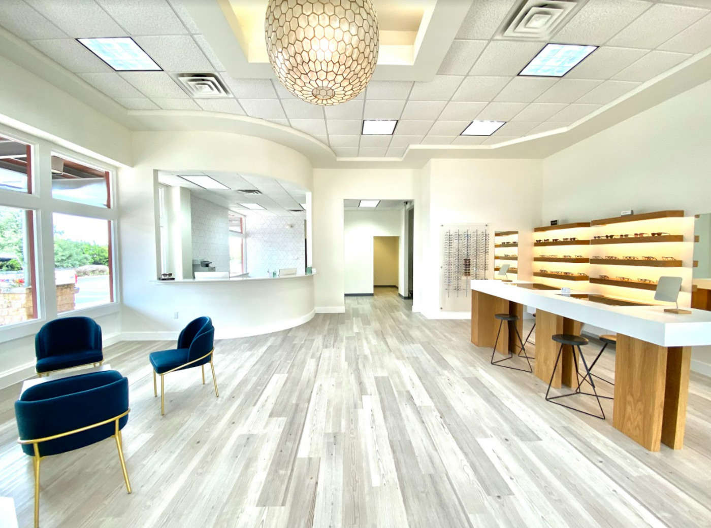 Bright optical eye center with eyewear displays, seating, and reception desk in Austin, TX by RedOven Builds