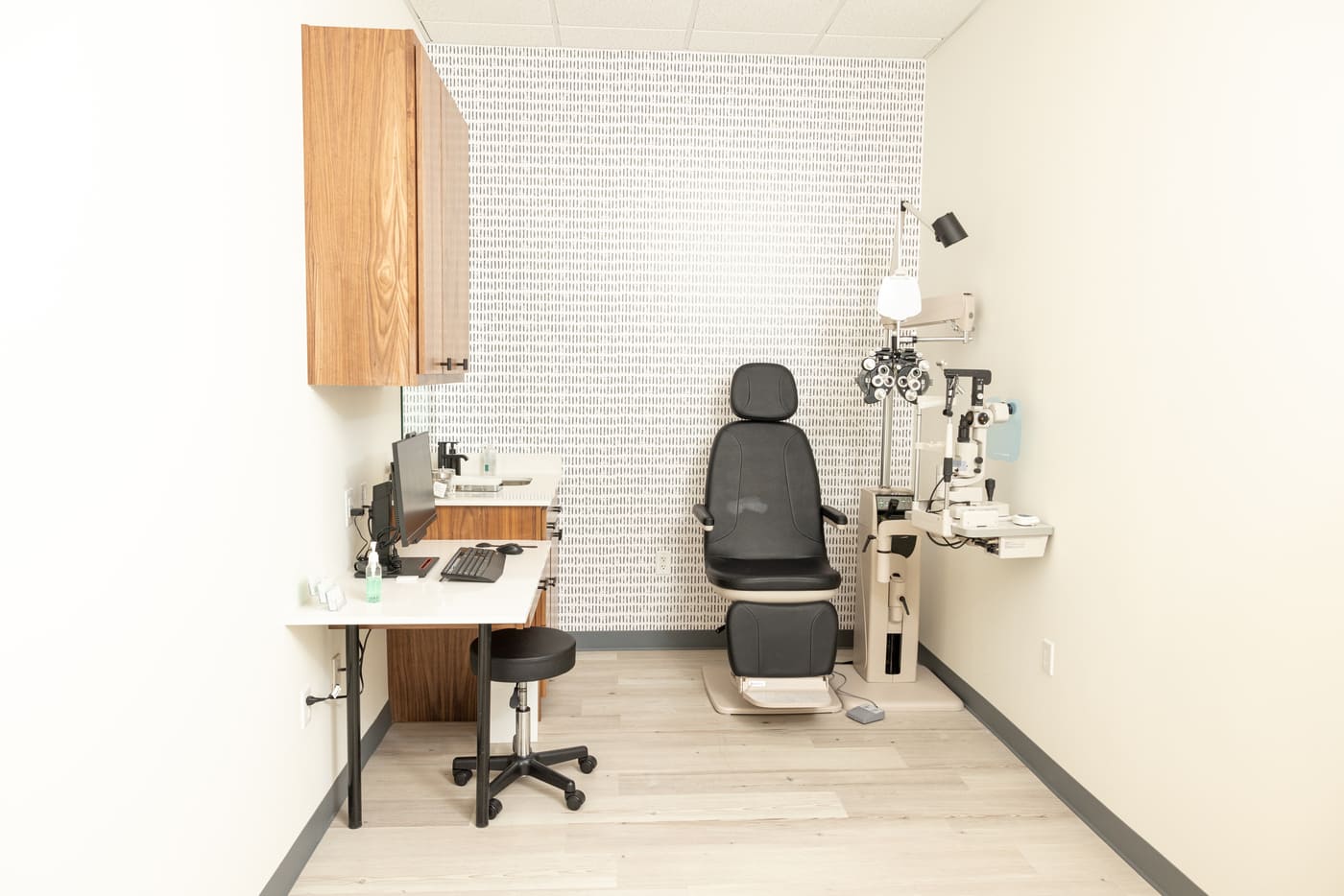 Eye exam room with chair, equipment, and workspace in Austin, TX eye center by RedOven Builds
