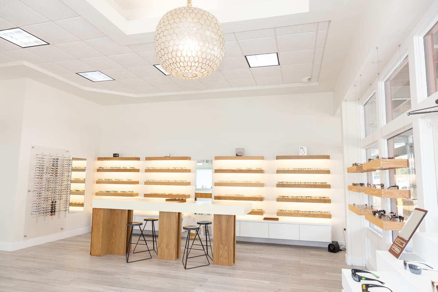 Eyewear display wall with shelving and central table in eye center in Austin, TX by RedOven Builds