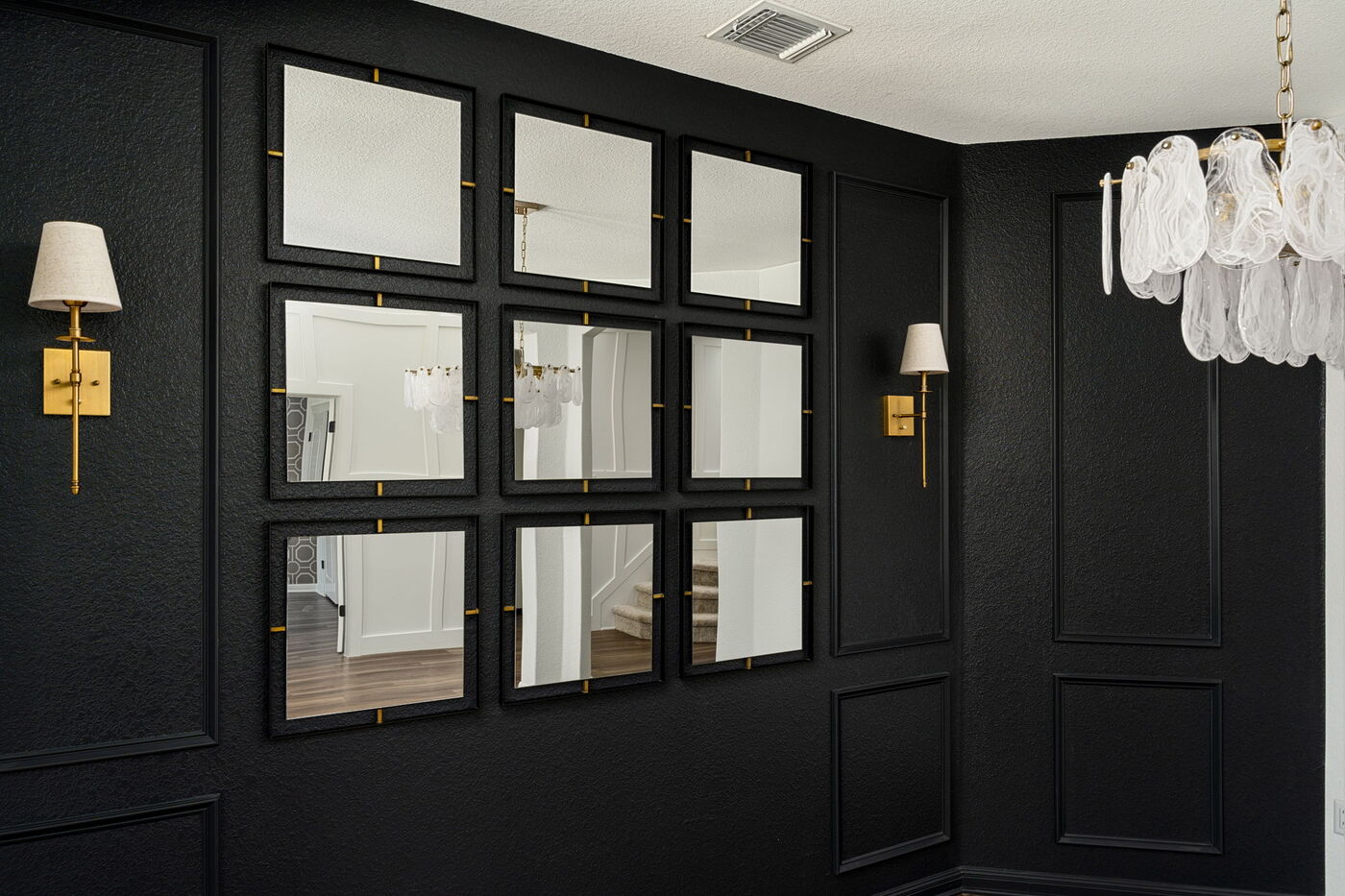 Black accent wall with grid mirrors and brass sconces in Austin, TX remodel by RedOven Builds