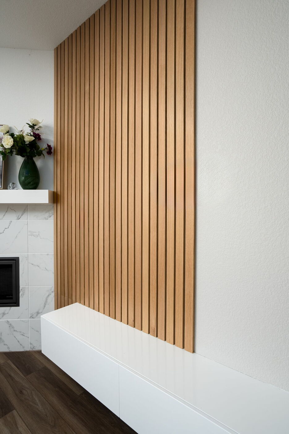 Close view of wood slat accent wall and fireplace in Austin, TX remodel by RedOven Builds