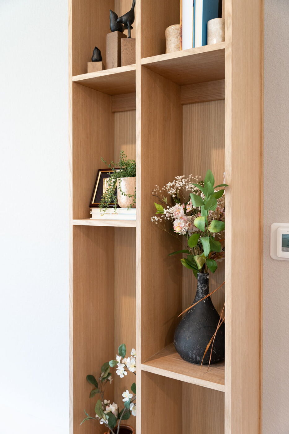 Close-up of built-in wood shelving with decor in Austin, TX remodel by RedOven Builds