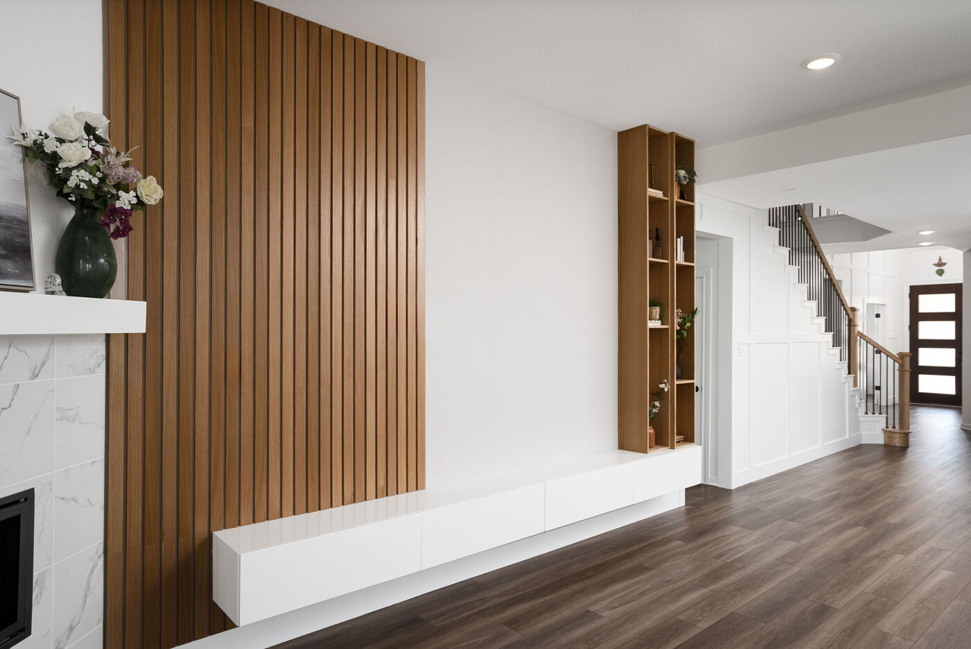 Modern living area with wood slat accent wall and built-in shelving in Austin, TX remodel by RedOven Builds