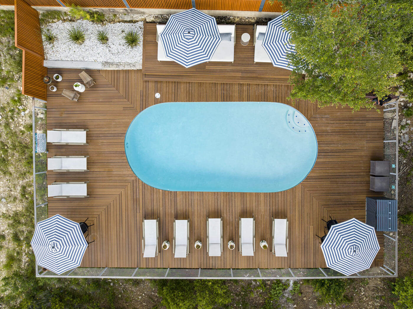 Aerial view of pool and deck of a hotel renovation in Austin, TX by RedOven Builds with lounge chairs and umbrellas
