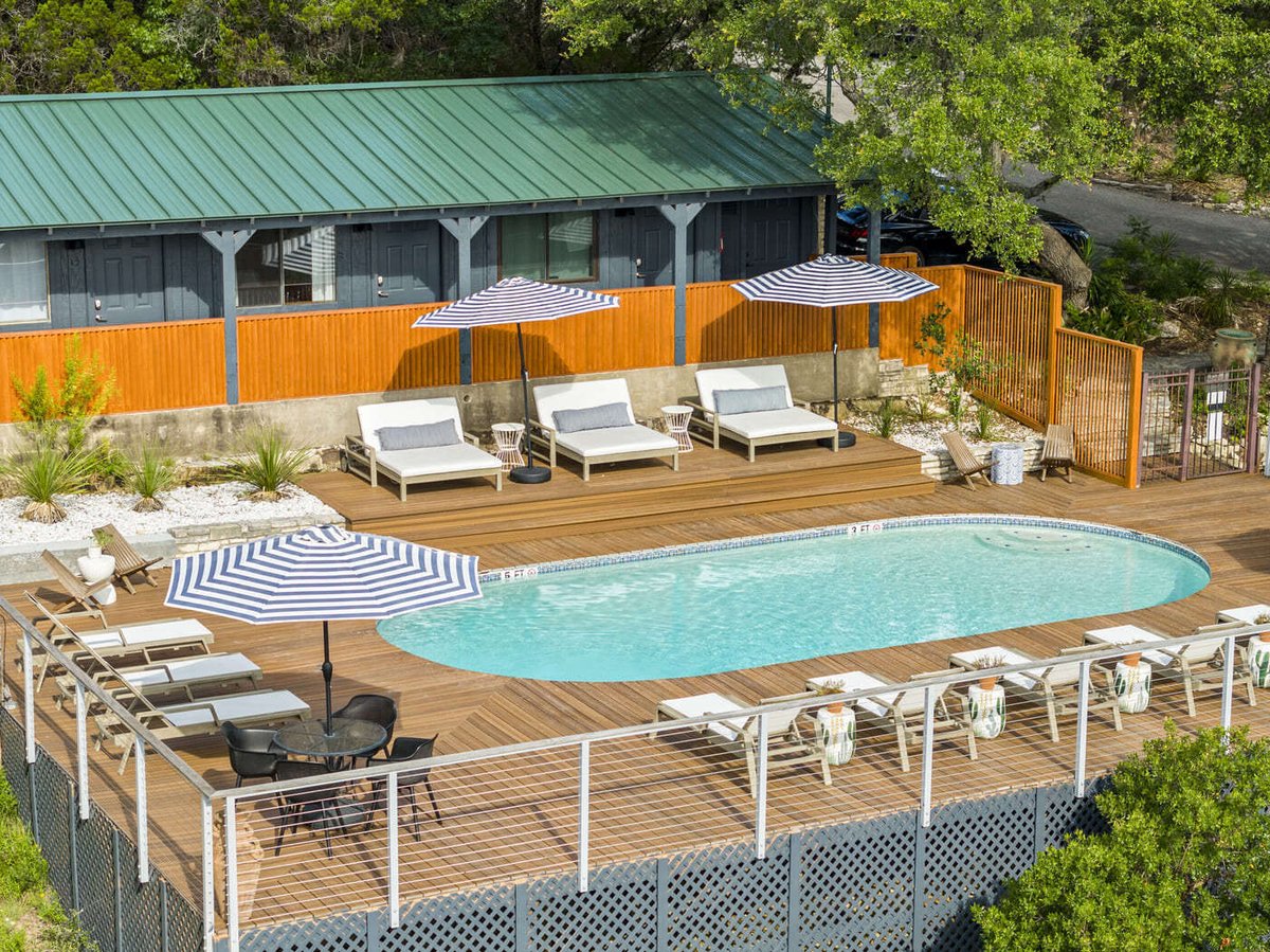 Elevated pool deck at a hotel renovation in Austin, TX by RedOven Builds with lounge chairs and modern fencing