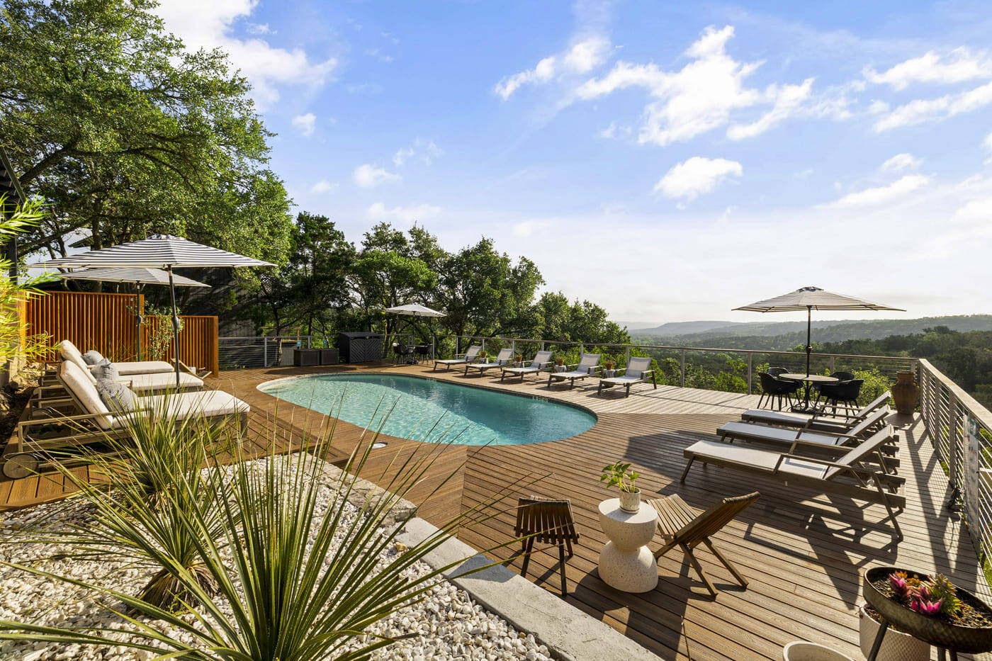 Hotel renovation pool deck in Austin, TX by RedOven Builds with lounge seating and scenic valley views