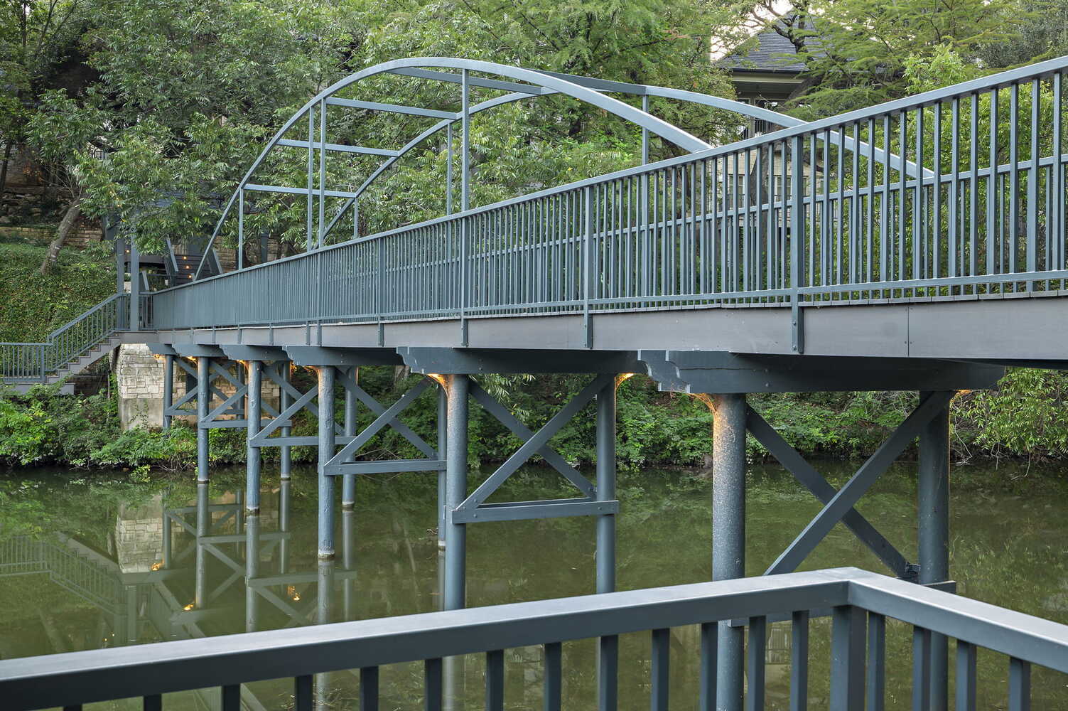 close view of elevated walkway and metal railing bridge by RedOven Builds in Austin, TX