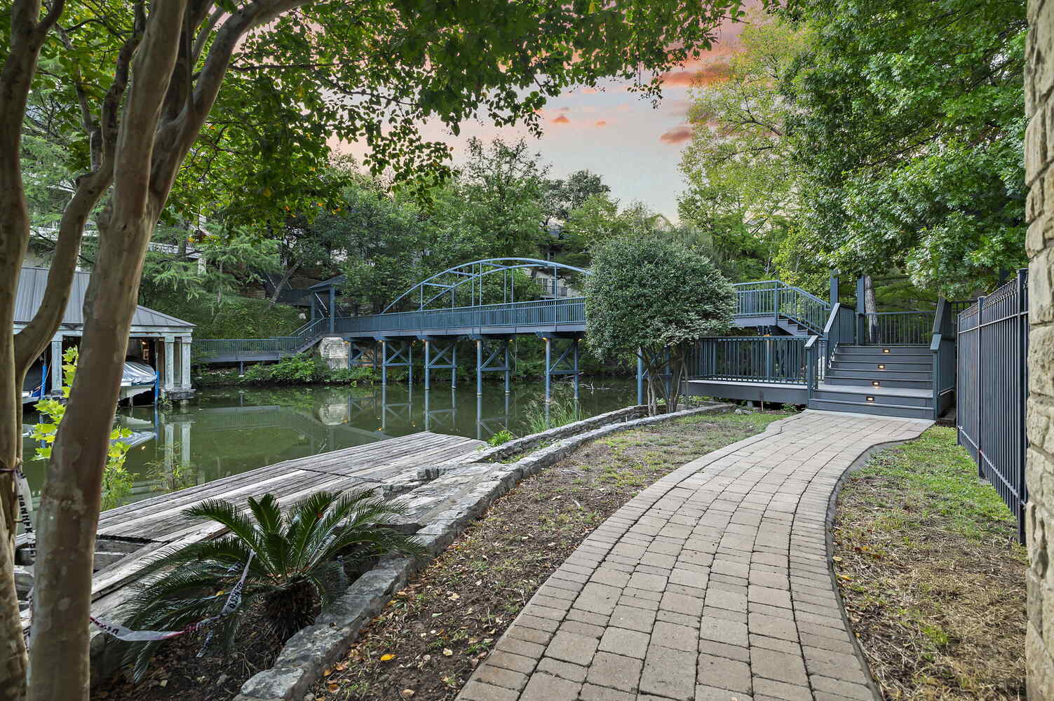 curved paver walkway leading to custom pedestrian bridge by RedOven Builds at 4408 Long Champ Dr Austin, TX commercial remodel project