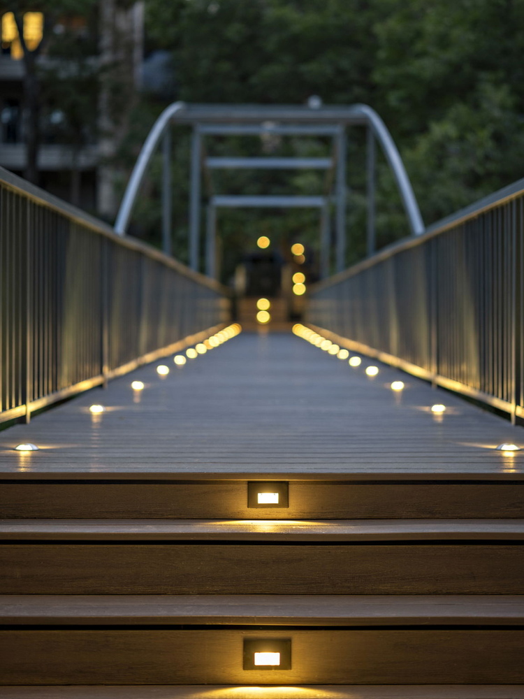 low angle view of illuminated bridge deck and railing by RedOven Builds in Austin TX