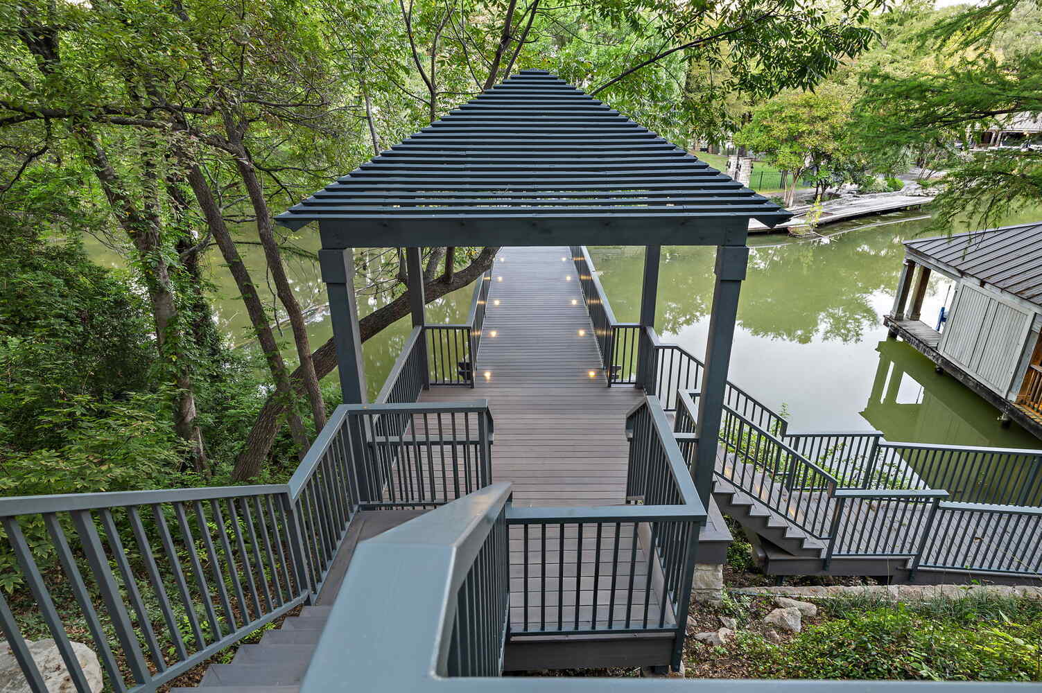 tiered outdoor stair system leading to covered deck by RedOven Builds in Austin, TX