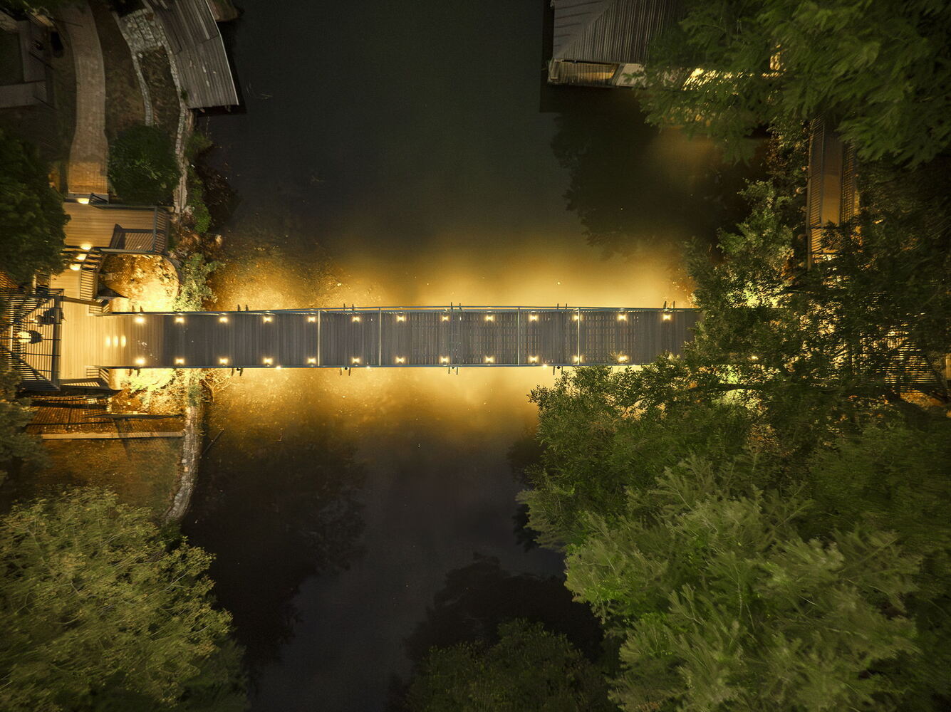 vertical aerial of lit pedestrian bridge from RedOven Builds commercial remodel Austin TX
