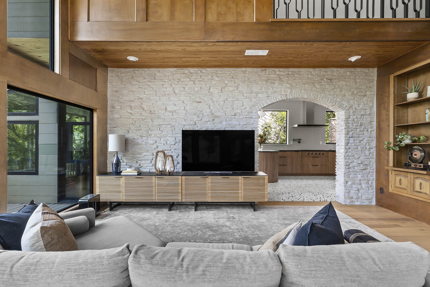 Austin TX remodel by RedOven Builds showcasing modern living space with media console and arched kitchen opening