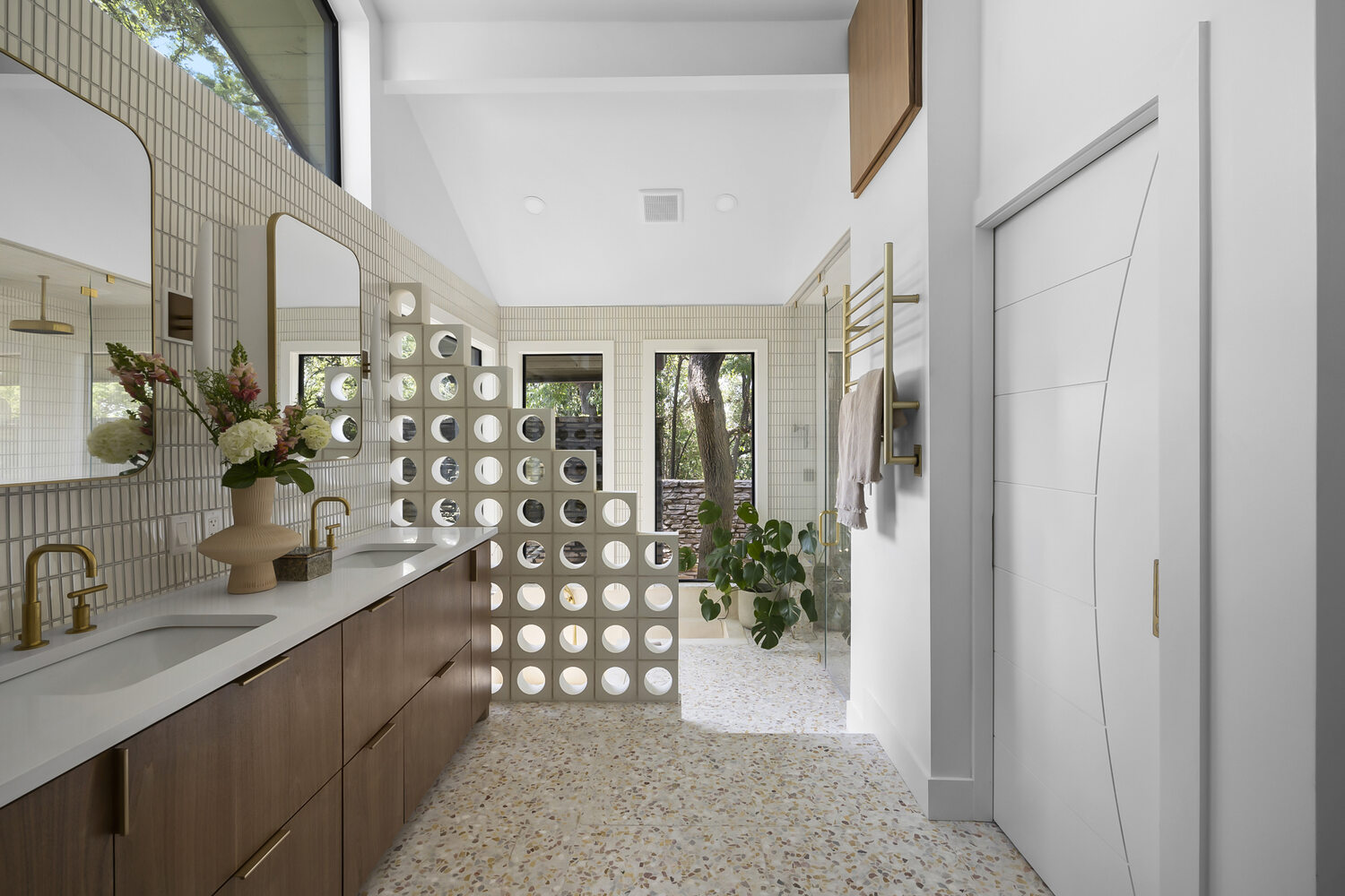 Bright modern bathroom vanity with terrazzo floors in a full home remodel by RedOven Builds in Austin, TX