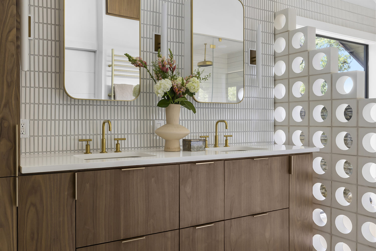 Close-up of double vanity with gold fixtures in a RedOven Builds bathroom remodel in Austin, TX