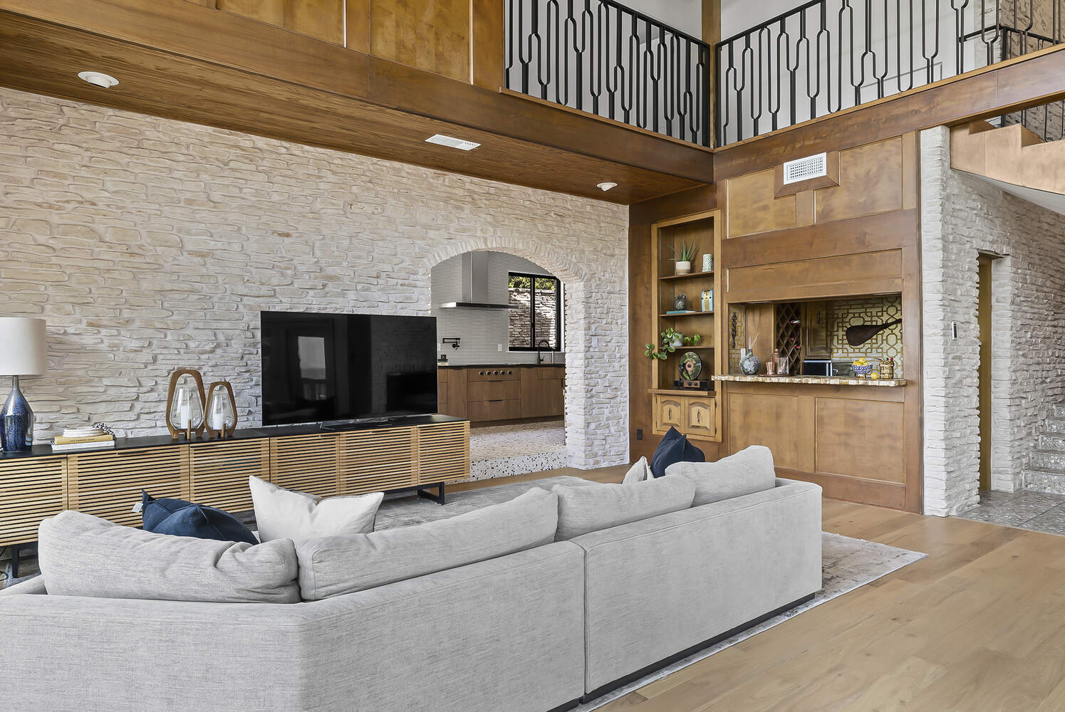 Contemporary living room in Austin TX full remodel by RedOven Builds with built-in bar and wood paneling