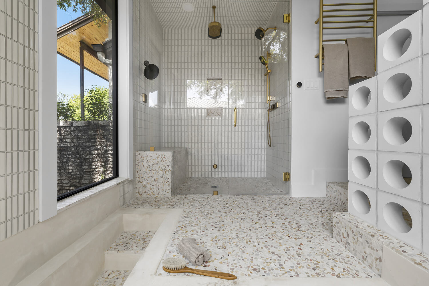 Contemporary shower with terrazzo flooring and glass walls in a RedOven Builds remodel in Austin, TX