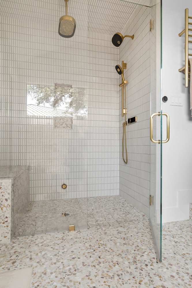 Luxury bathroom shower design with glass enclosure and brass fixtures in Austin TX home remodel by RedOven Builds