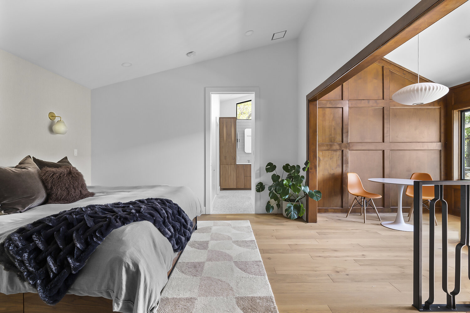 Open bedroom design with adjacent seating area and wood accents in Austin TX by RedOven Builds
