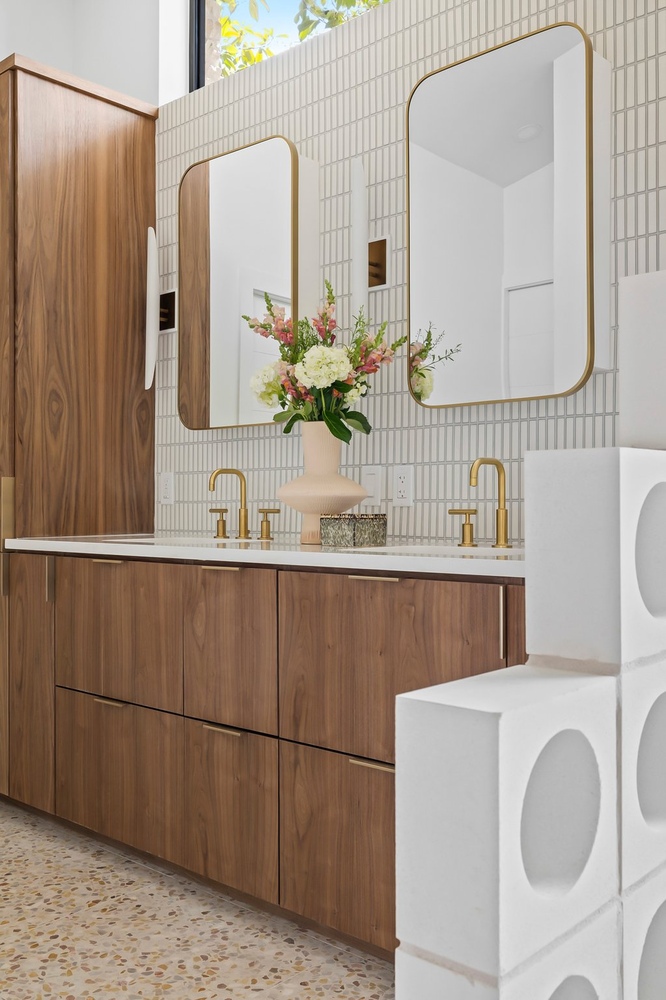 RedOven Builds Austin TX bathroom remodel with double vanity, terrazzo flooring, and modern mirrors