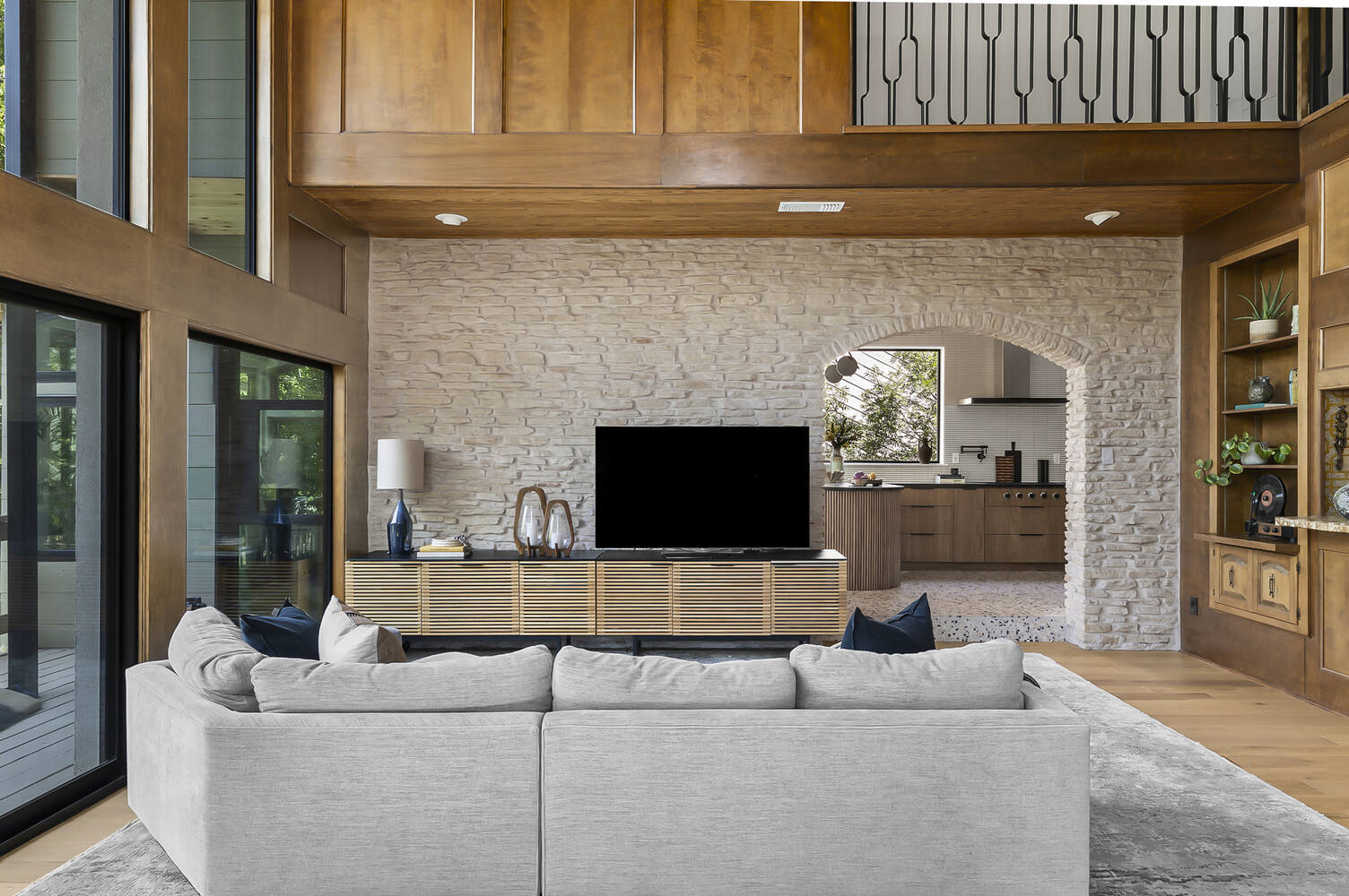 RedOven Builds full home remodel in Austin TX showing spacious living room with stone wall and open kitchen view