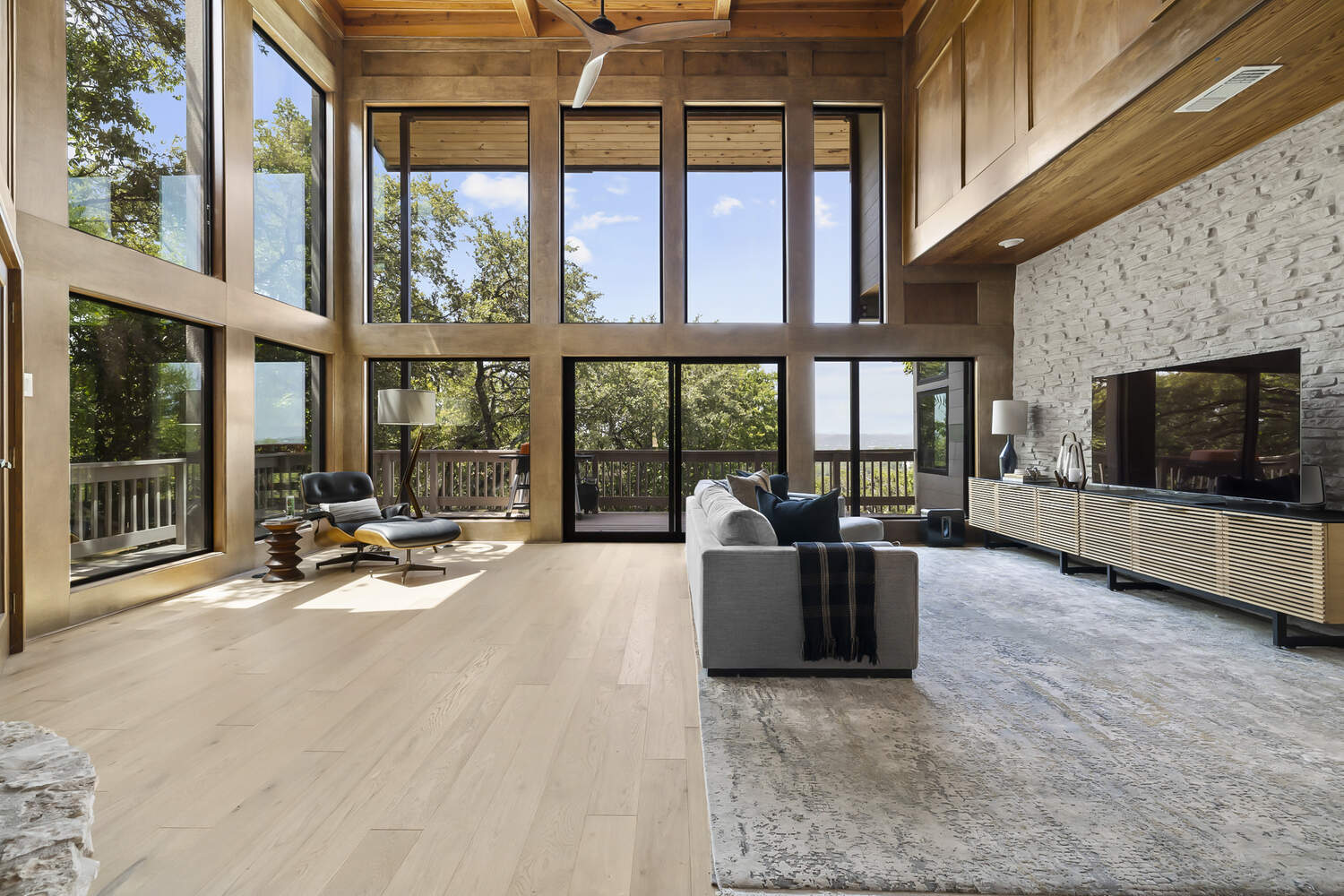 Spacious Austin TX living room remodel by RedOven Builds featuring large windows, wood accents, and open layout