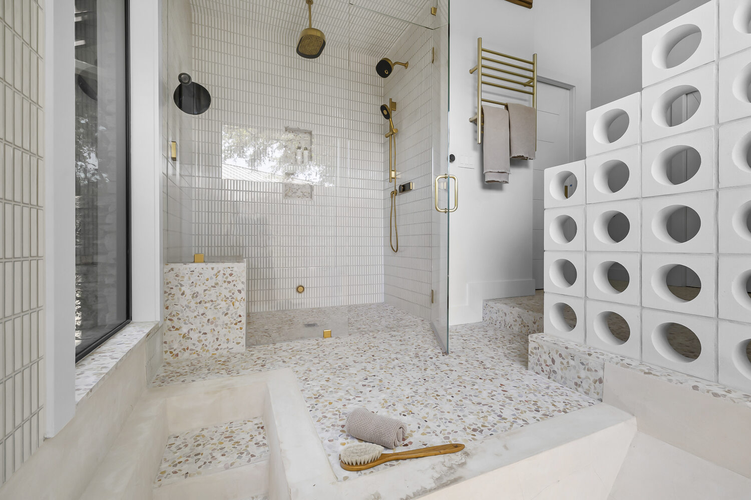 Walk-in shower with glass enclosure and terrazzo floors in a RedOven Builds remodel in Austin, TX