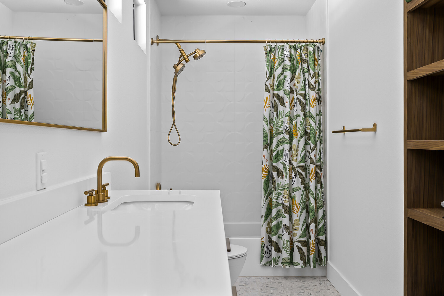 clean bathroom remodel with white surfaces and gold hardware in Austin TX by RedOven Builds