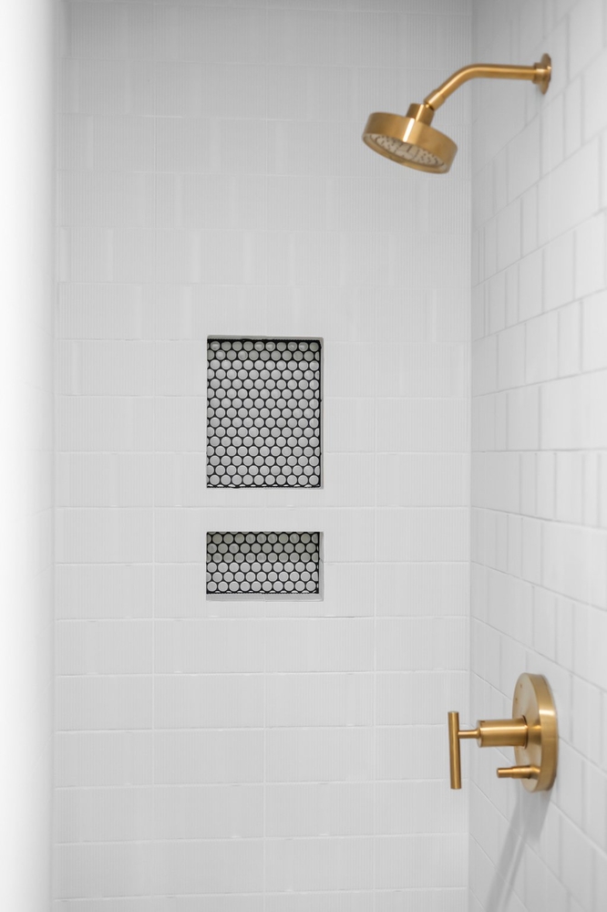 clean modern shower design with gold hardware and niche storage in Austin TX remodel