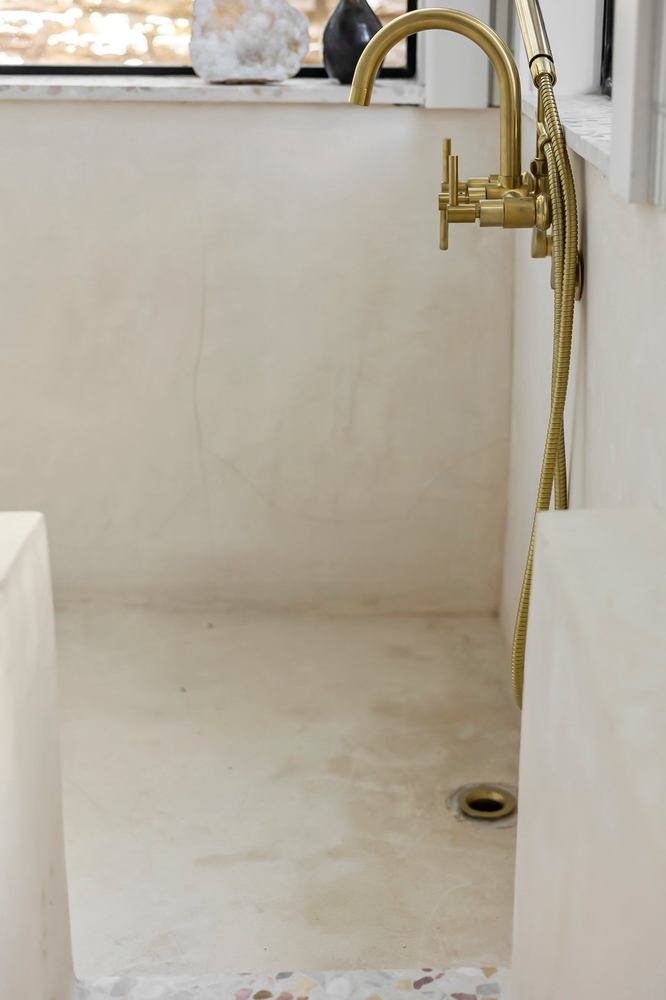 close-up of gold shower hardware in modern bathroom remodel by RedOven Builds Austin TX