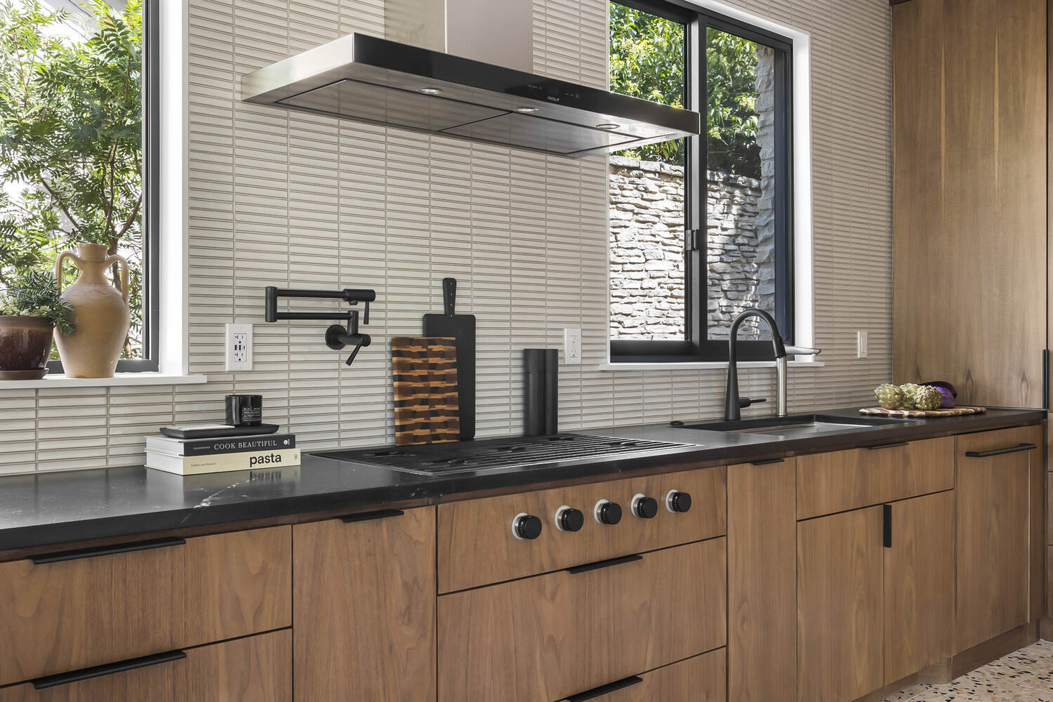 close-up of modern kitchen range area with wood cabinets and backsplash by RedOven Builds Austin TX