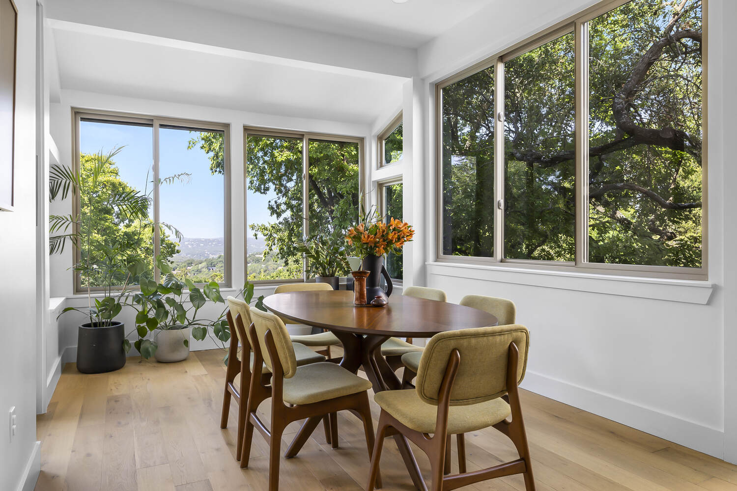 contemporary dining space with natural light and wood table in Austin TX full home remodel by RedOven Builds