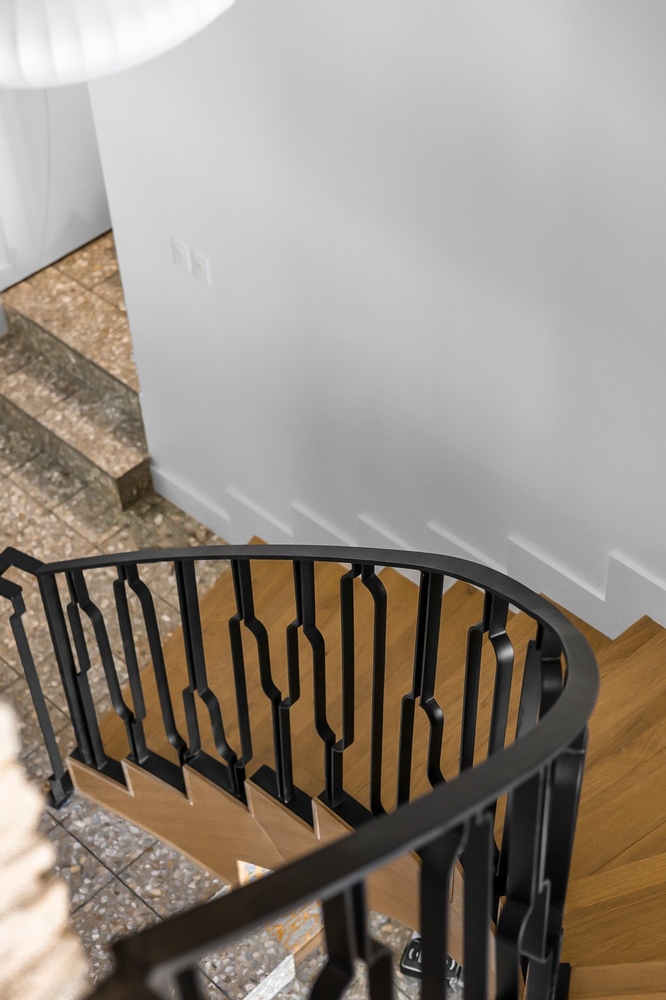 curved staircase with black metal railing and wood steps by RedOven Builds Austin TX