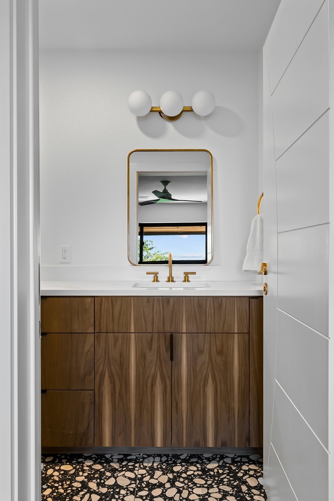 custom bathroom vanity with wood cabinets and gold faucet by RedOven Builds Austin TX remodel