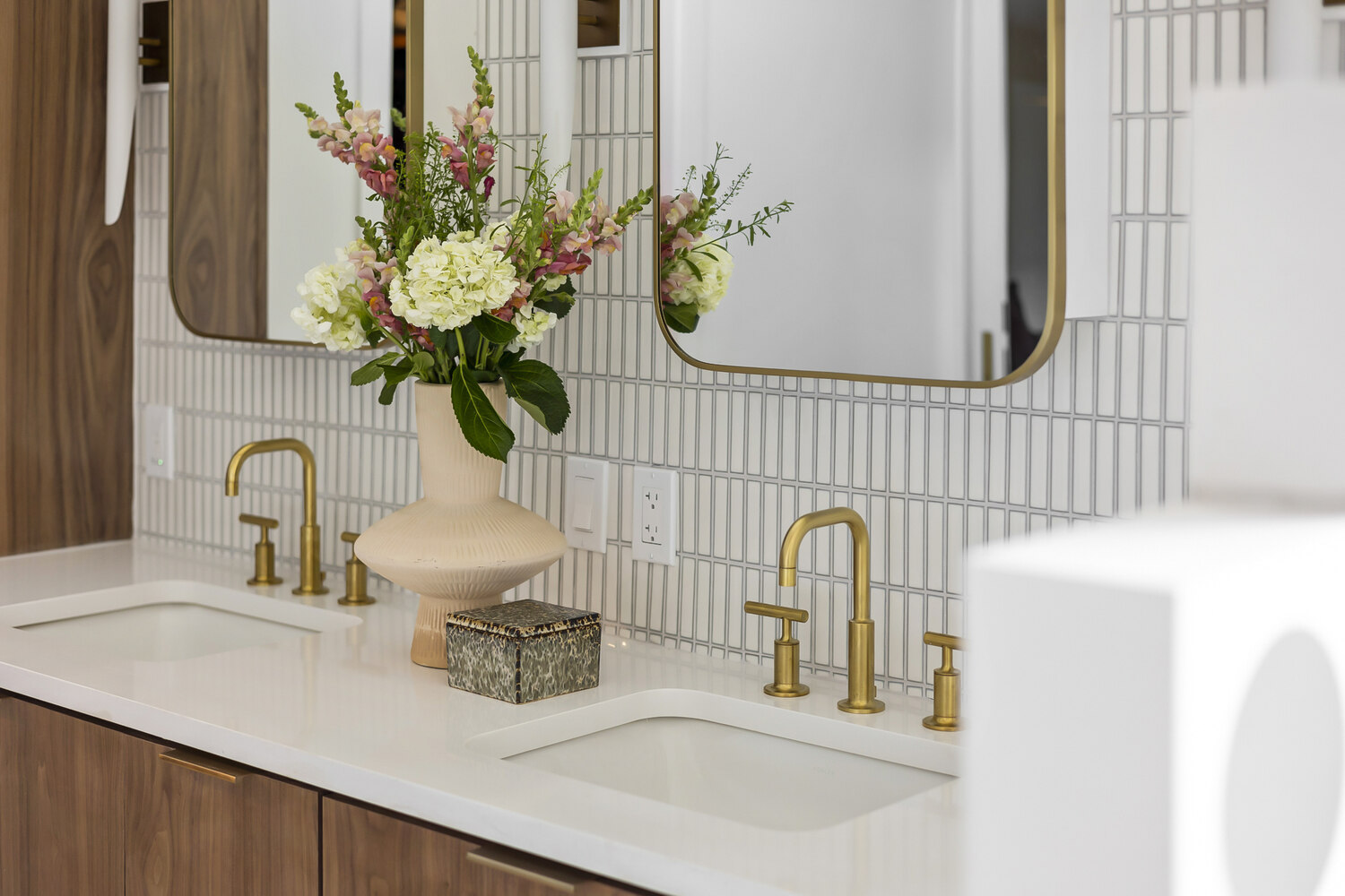 double vanity bathroom with brass fixtures and floral decor in Austin TX remodel by RedOven Builds