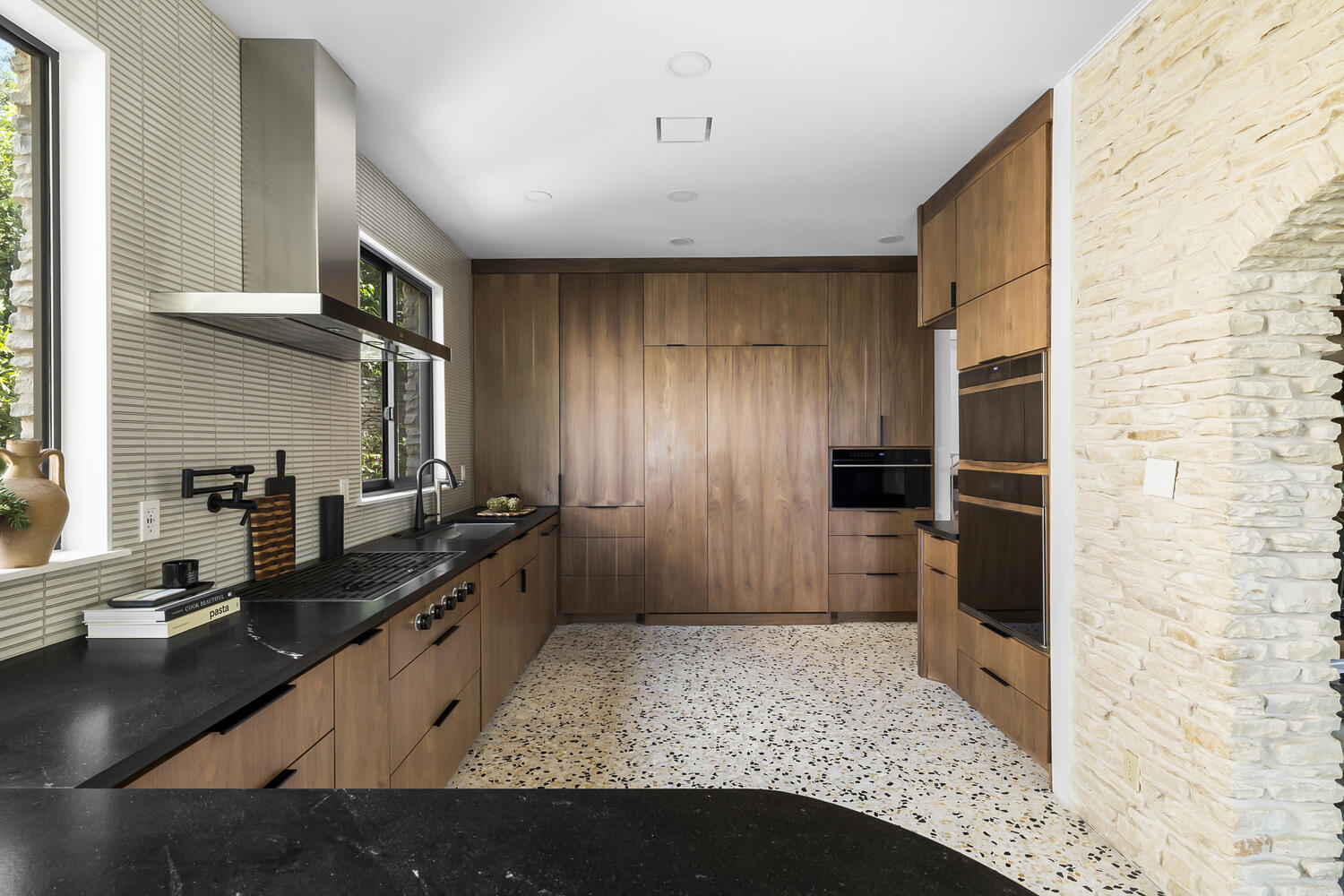 full kitchen remodel featuring custom cabinetry and stone wall detail by RedOven Builds Austin TX