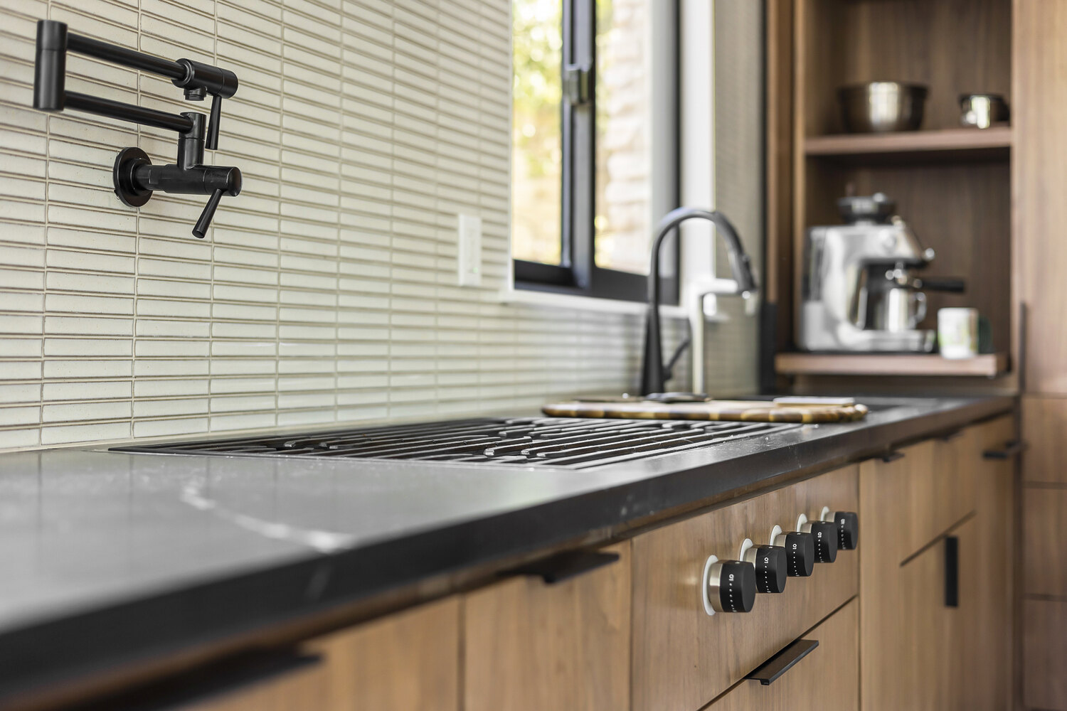 modern kitchen design with built in cooktop and wood cabinets by RedOven Builds in Austin TX