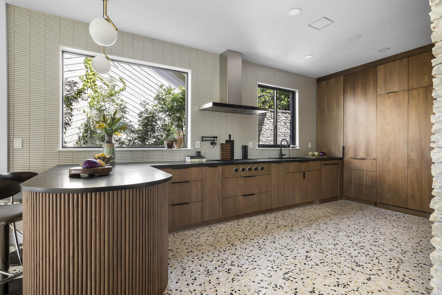 modern kitchen island with fluted wood detail and pendant lighting by RedOven Builds Austin TX remodel