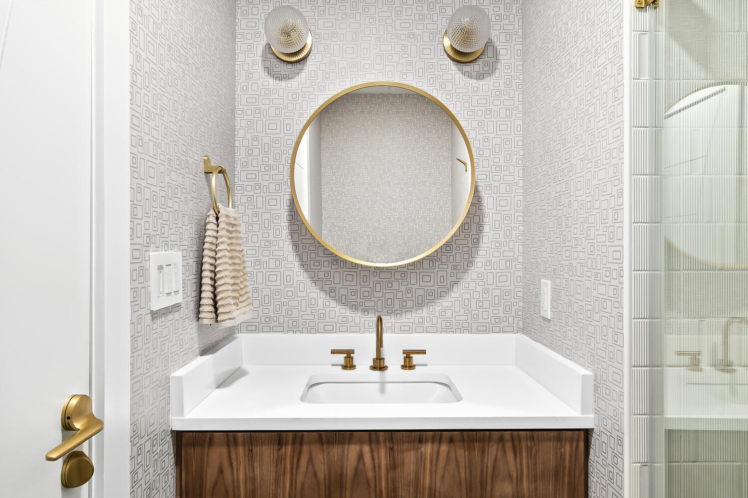 modern powder bathroom vanity with gold fixtures and geometric wallpaper by RedOven Builds in Austin TX full home remodel