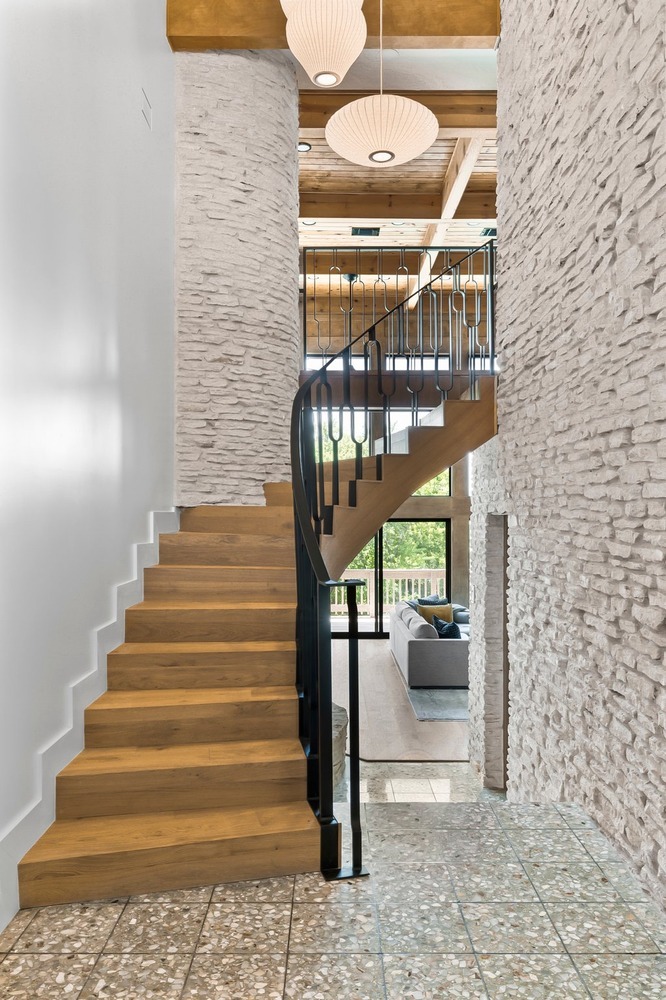 modern staircase with wood treads and black railing in Austin TX full home remodel by RedOven Builds
