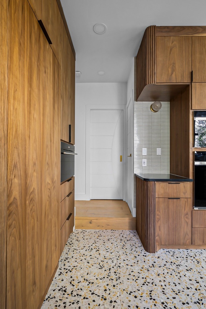 narrow kitchen corridor featuring custom wood cabinets and terrazzo tile floor by RedOven Builds Austin TX remodel