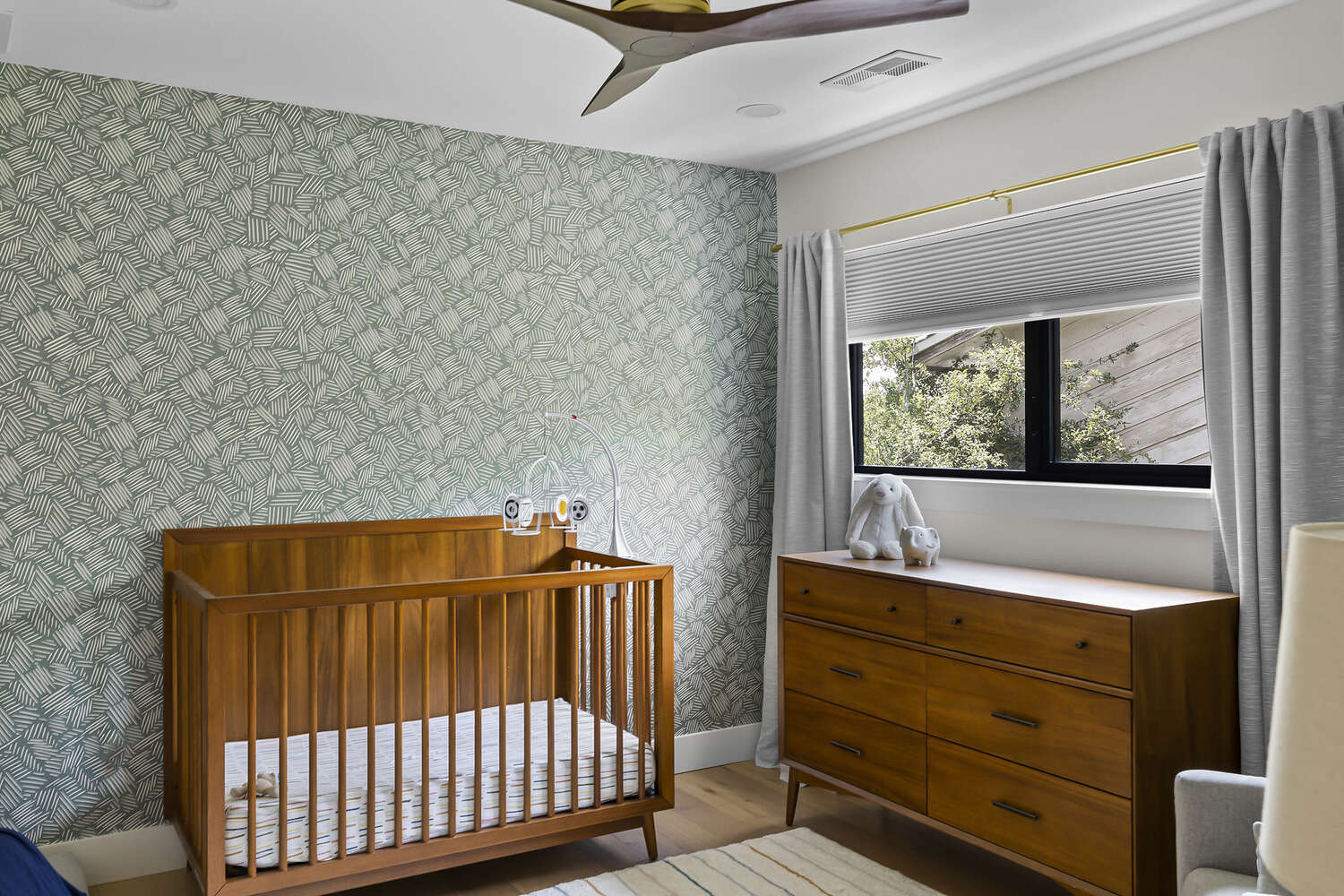nursery room with wooden crib and green accent wall in Austin TX by RedOven Builds
