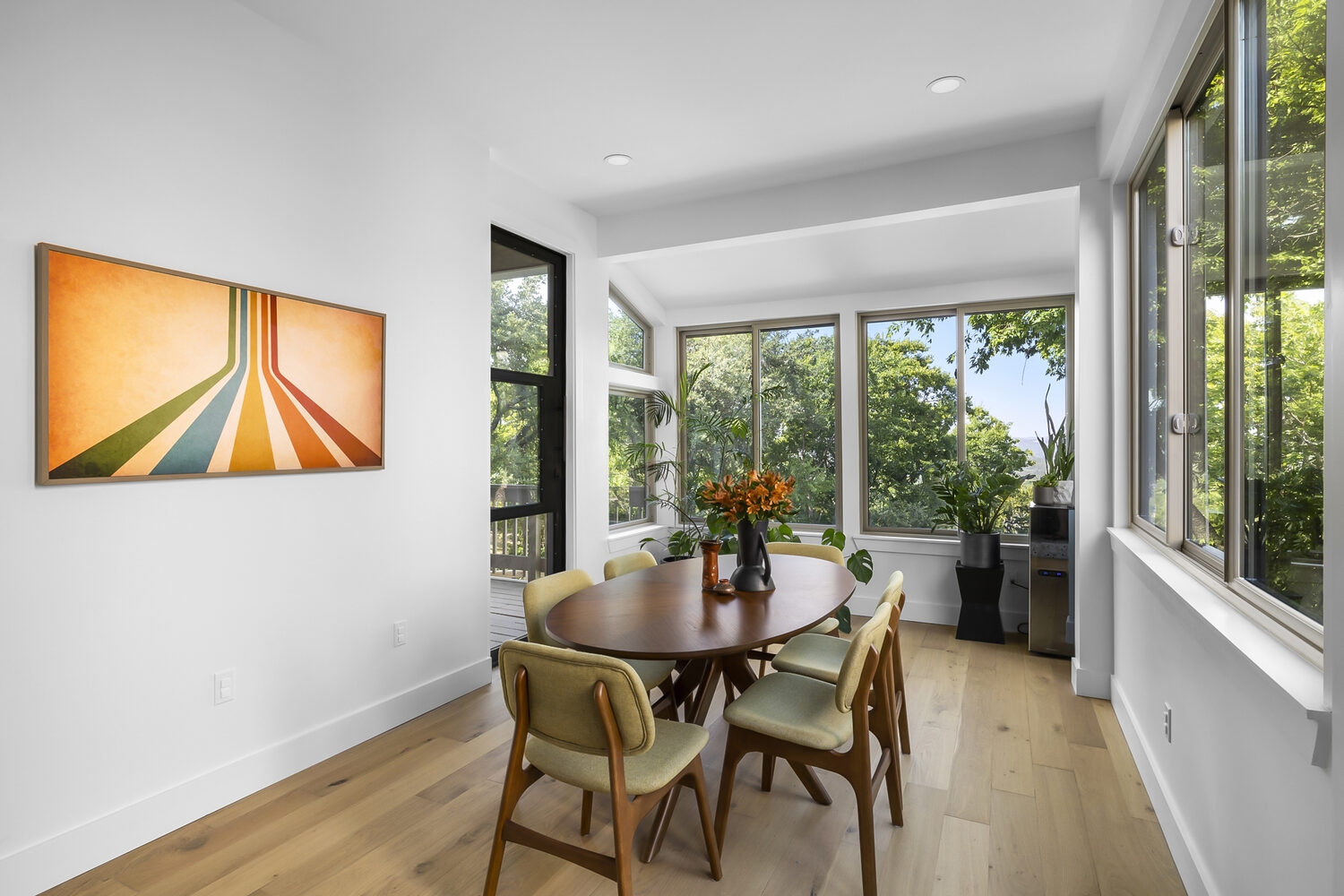 open concept dining room with modern artwork and large windows in Austin TX full home remodel by RedOven Builds